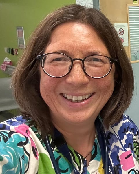 Dr Emma Lim is pictured in bright coloured hospital scrubs on a hospital ward 